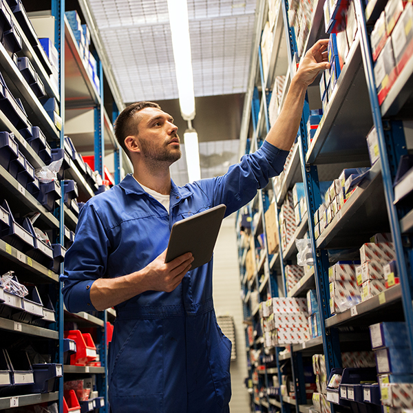 A worker organizes products on a warehouse floor.